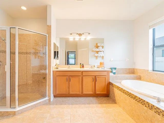 a spacious bathroom with a tub sink and mirror
