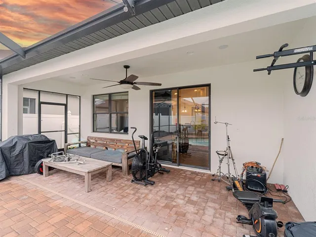 a living room with furniture gym equipment and large windows