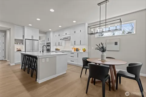 a kitchen with a table chairs refrigerator and cabinets