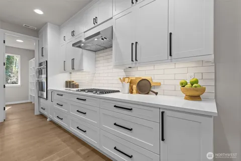 a kitchen with stainless steel appliances cabinets and wooden floor