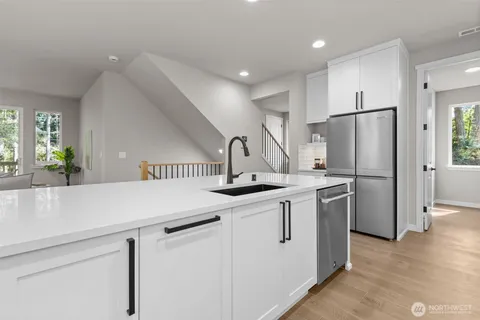 a kitchen with stainless steel appliances a sink and a refrigerator