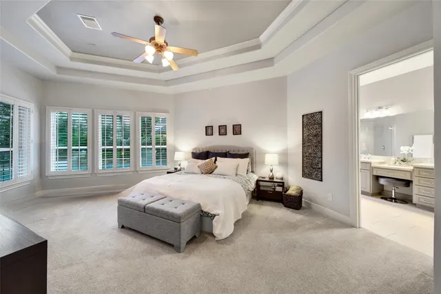a spacious bedroom with a bed and a chandelier