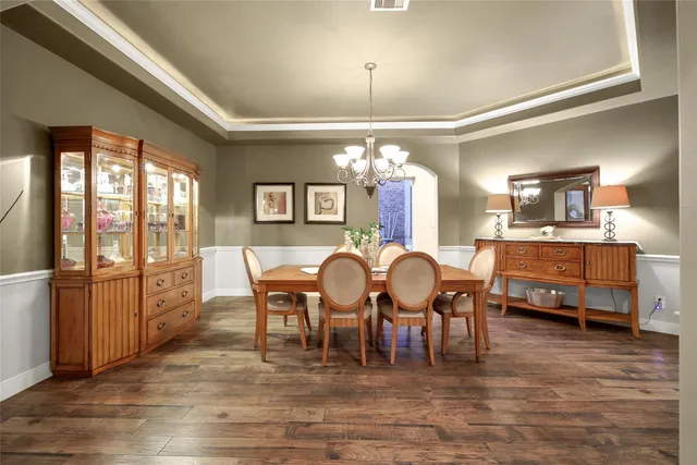 a view of dining room and livingroom with furniture wooden floor a chandelier