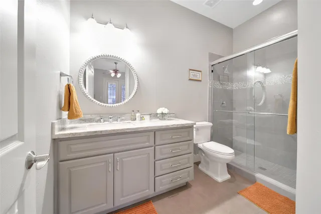 a bathroom with a sink a toilet and shower