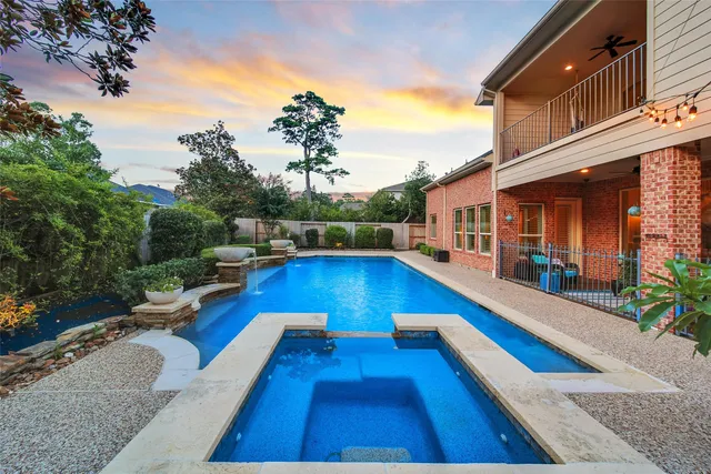 a view of swimming pool with lounge chair and dinning table under an umbrella