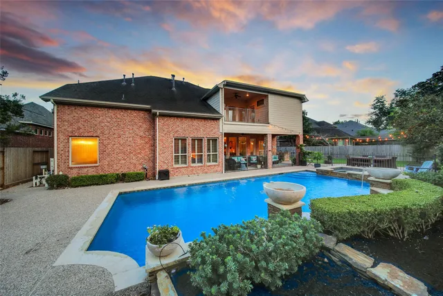 a view of a house with pool and chairs