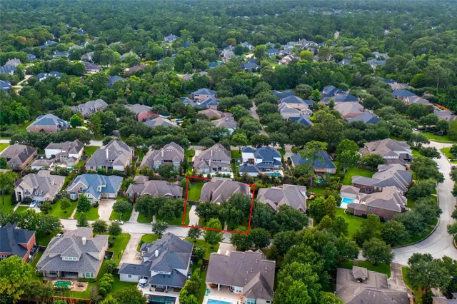 an aerial view of residential houses with outdoor space and trees