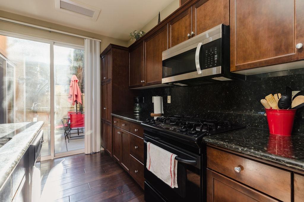 3953 Harlan Ranch Boulevard Clovis, CA 93619 - Photo 7 of 31 a kitchen with stainless steel appliances granite countertop a stove microwave and sink