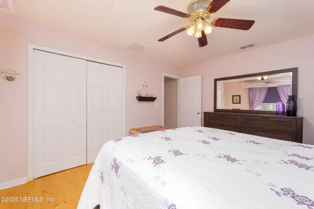 a spacious bedroom with a bed a table and large windows