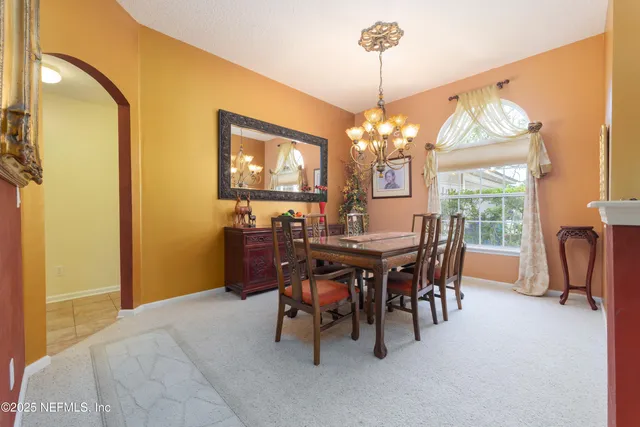 a view of a dining room with furniture and a chandelier