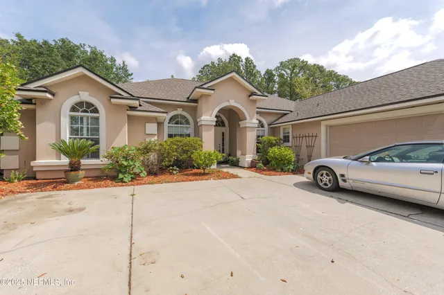 a view of a house with a backyard and a tree