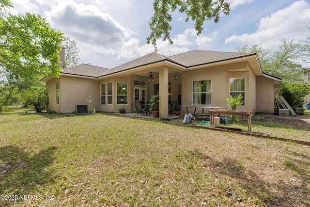 a view of a house with backyard and sitting area