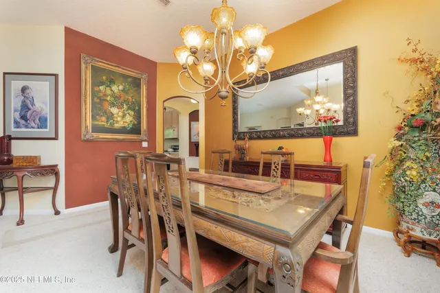a view of a dining room with furniture and chandelier
