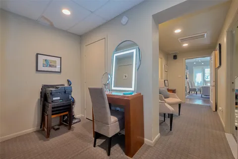 a view of a workspace with furniture and a window