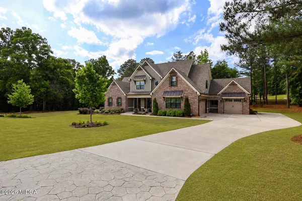 a front view of house with yard and trees around