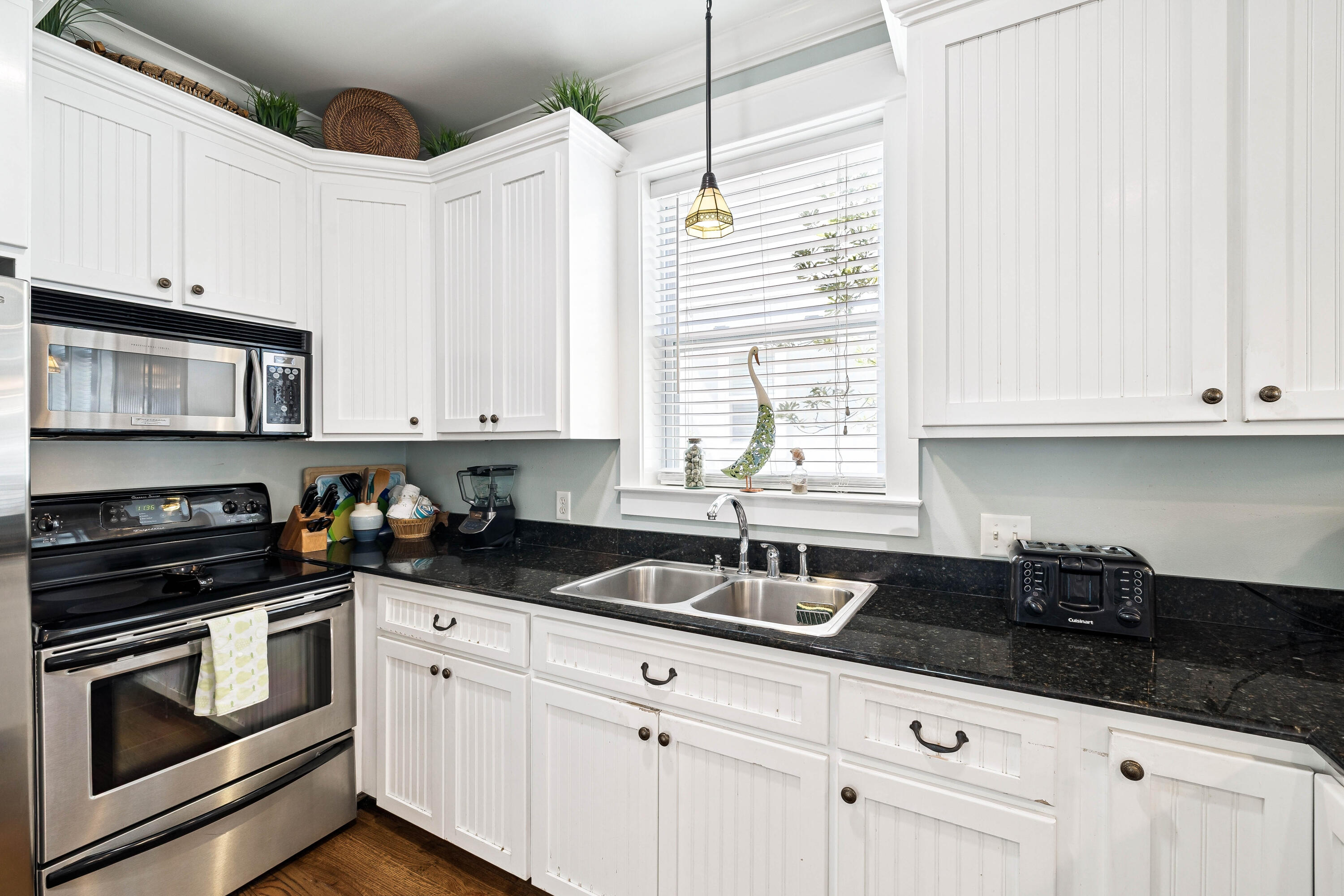 54 Surfer Lane Seacrest, FL 32461 - Photo 19 of 47 a kitchen with granite countertop white cabinets and black appliances