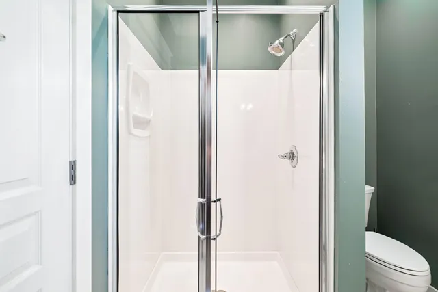 a bathroom with a glass shower door and a glass door