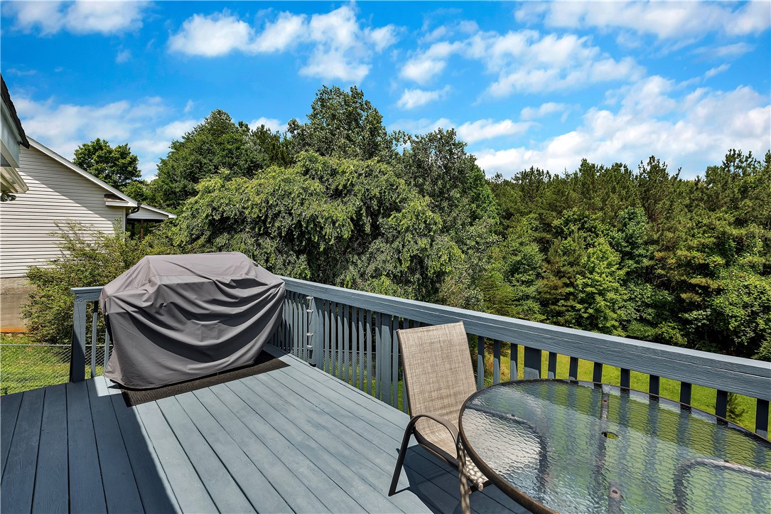131 Morgan Road West Union, SC 29696 - Photo 21 of 39 An inviting deck extends outdoor living, overlooking verdant trees under a blue sky.