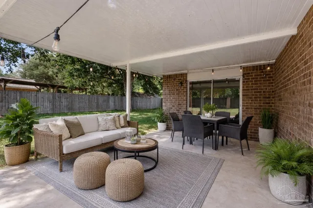 a backyard of a house with plants and large tree