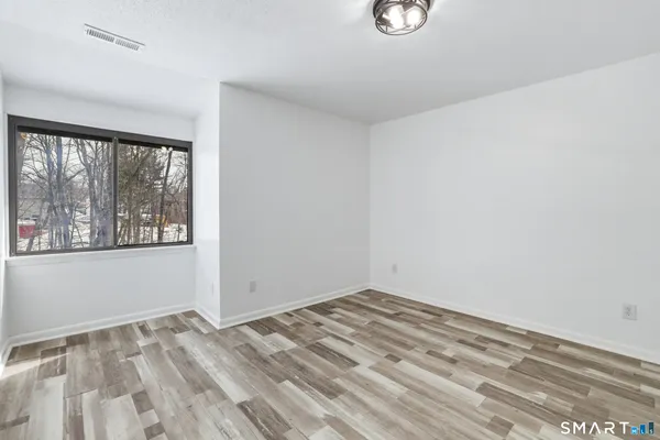 a view of empty room with wooden floor