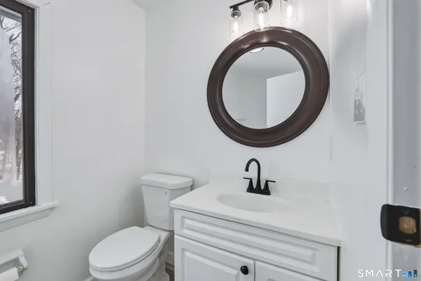 a bathroom with a sink a toilet and a mirror