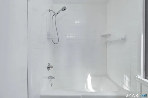 a bathroom with a bath tub with a shower