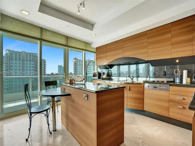 a kitchen with stainless steel appliances kitchen island granite countertop dining table and chairs