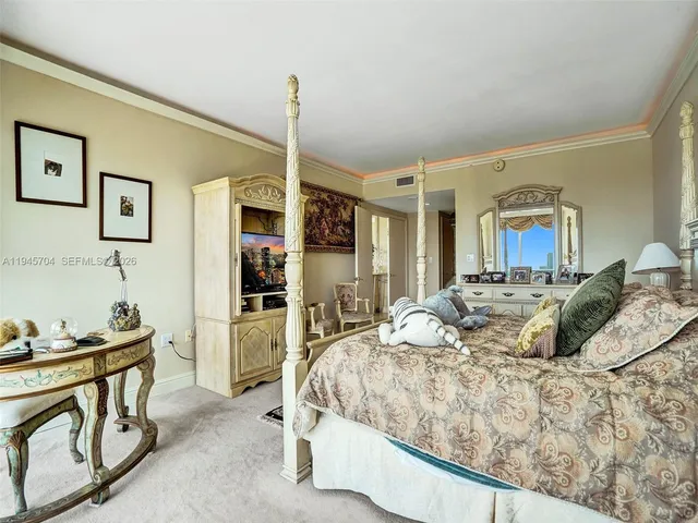 a bed sitting in a bedroom and kitchen view