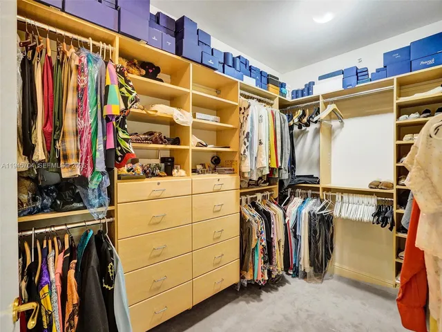 a view of walk in closet with clothes
