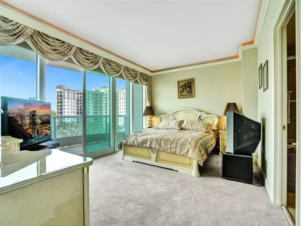 a spacious bedroom with a bed and a tv