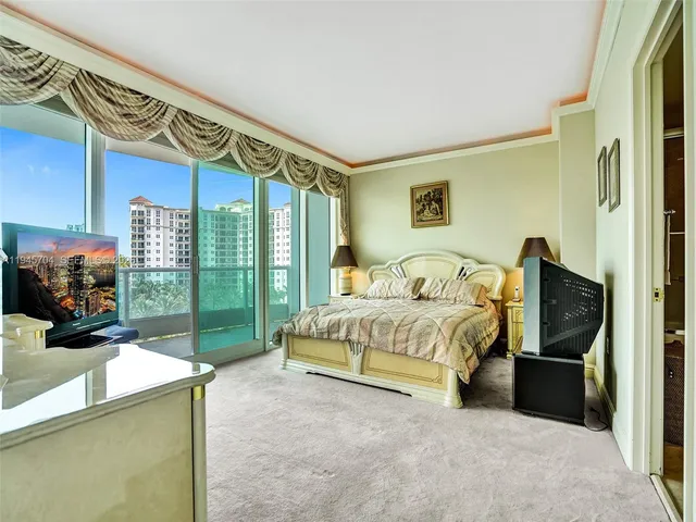 a spacious bedroom with a bed and a tv