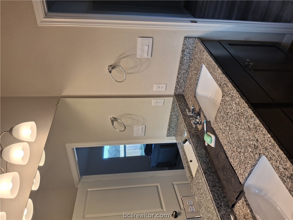 1864 Taggart Trail Bryan, TX 77807 - Photo 11 of 12 a bathroom with a granite countertop sink and a mirror