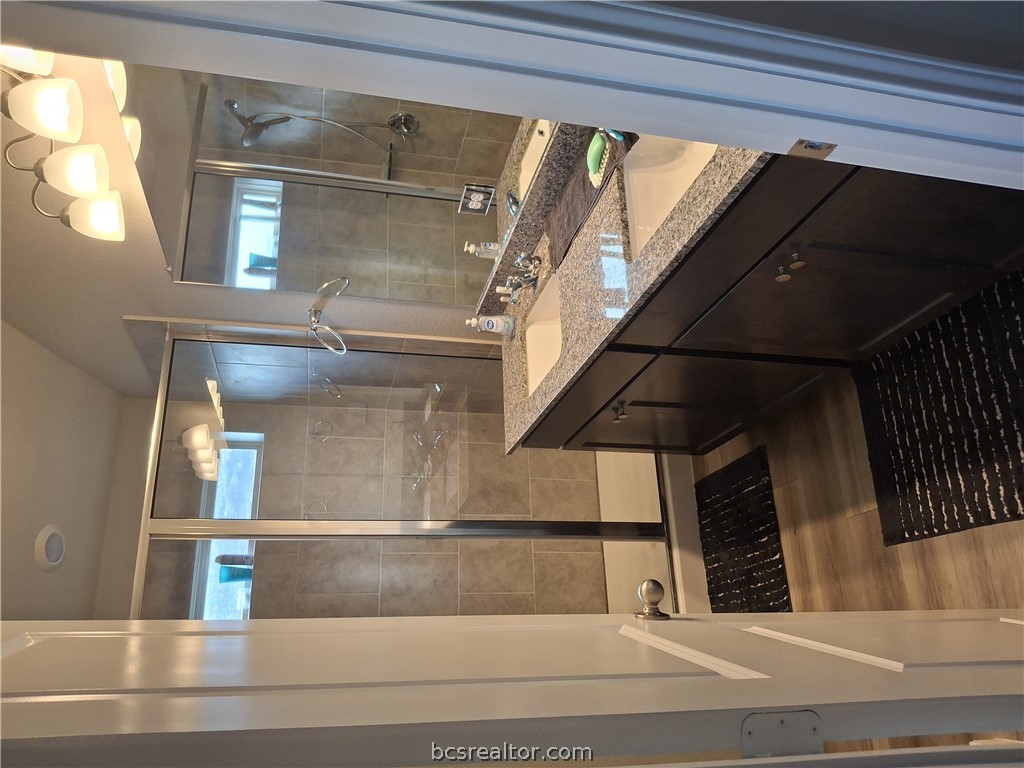 1864 Taggart Trail Bryan, TX 77807 - Photo 10 of 12 a bathroom with a granite countertop sink a mirror and a shower