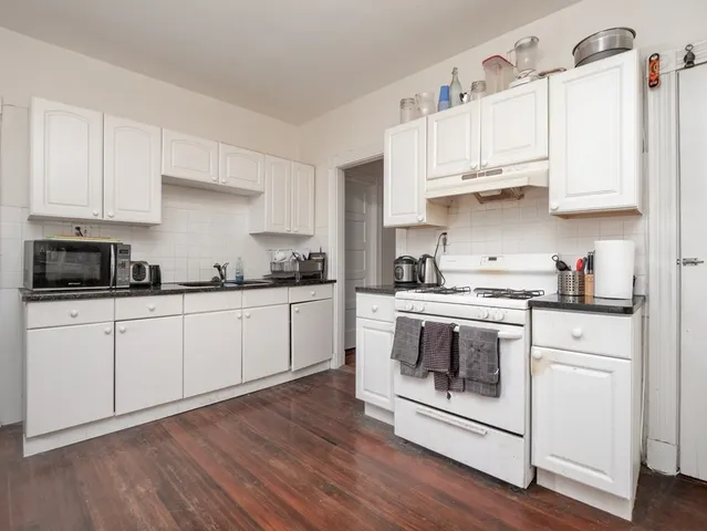 a kitchen with cabinets a sink and steel appliances