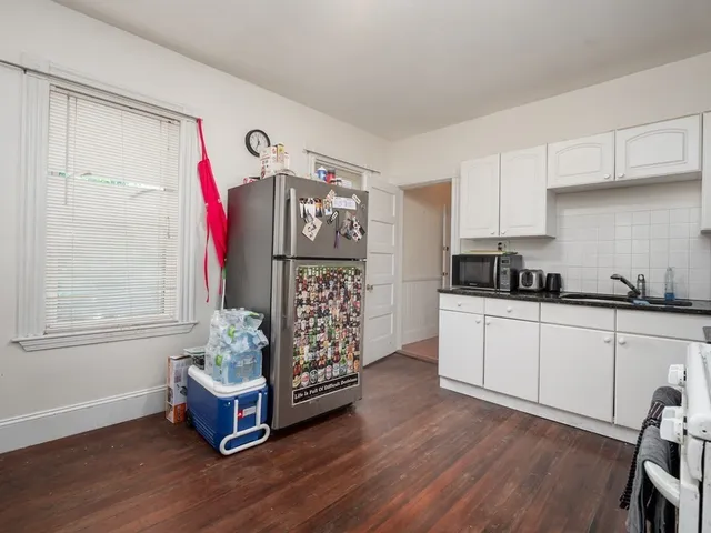 a kitchen with granite countertop a stove a sink and a refrigerator