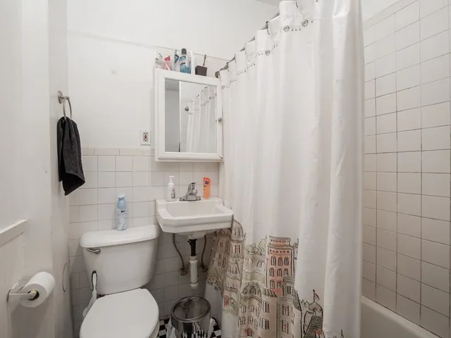 a bathroom with a sink a toilet and shower curtain