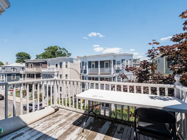 a view of a house with a deck and furniture