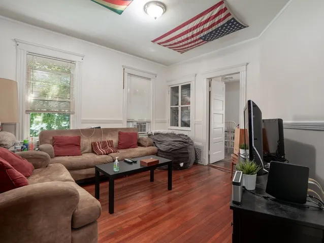 a living room with furniture a flat screen tv and a window