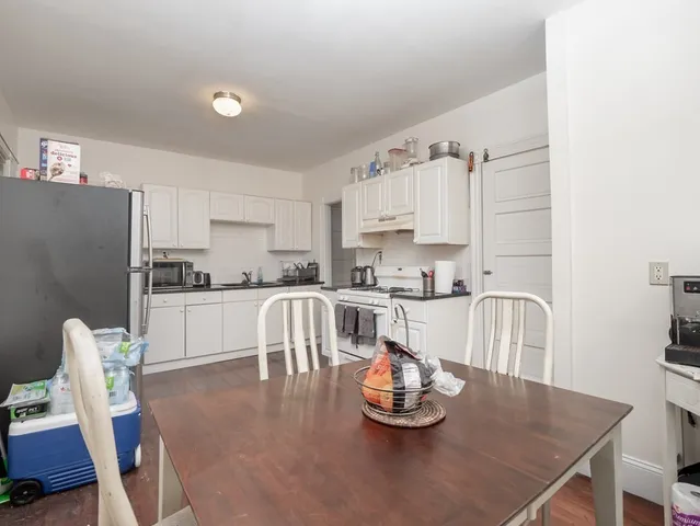 a kitchen with stainless steel appliances a dining table and chairs
