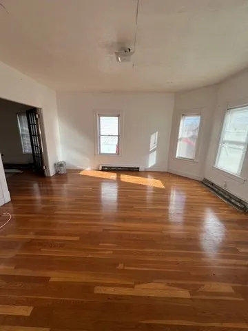 a view of room with window and wooden floor
