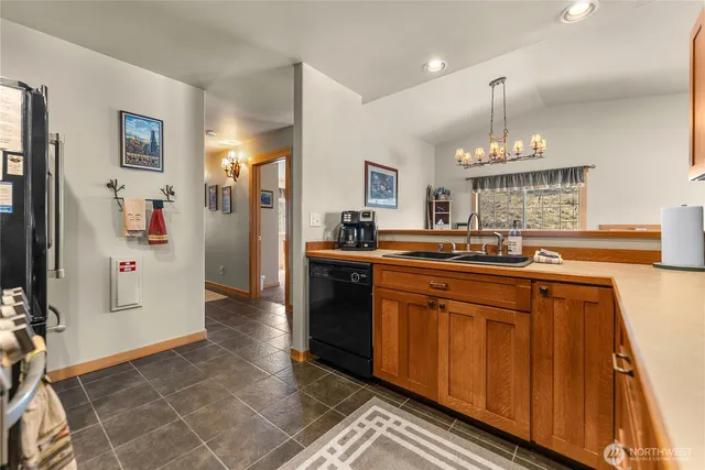 a kitchen with stainless steel appliances granite countertop a sink and a refrigerator