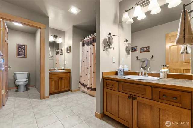 a spacious bathroom with a double vanity sink a mirror and a shower
