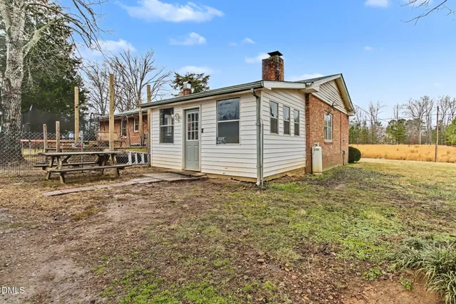 a view of a patio with table and chairs and floor to ceiling window with wooden fence
