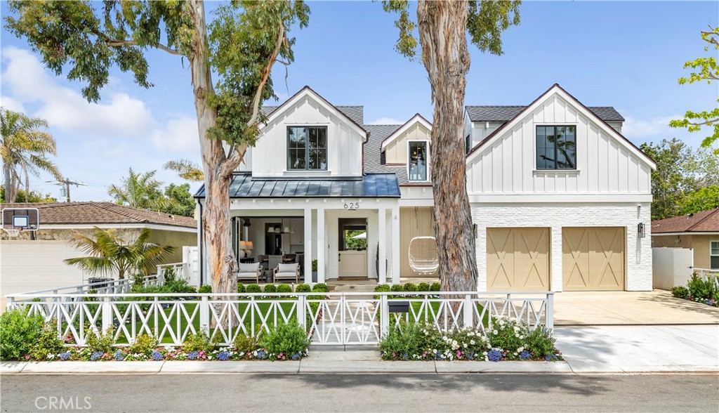 a front view of a house with a yard and potted plants
