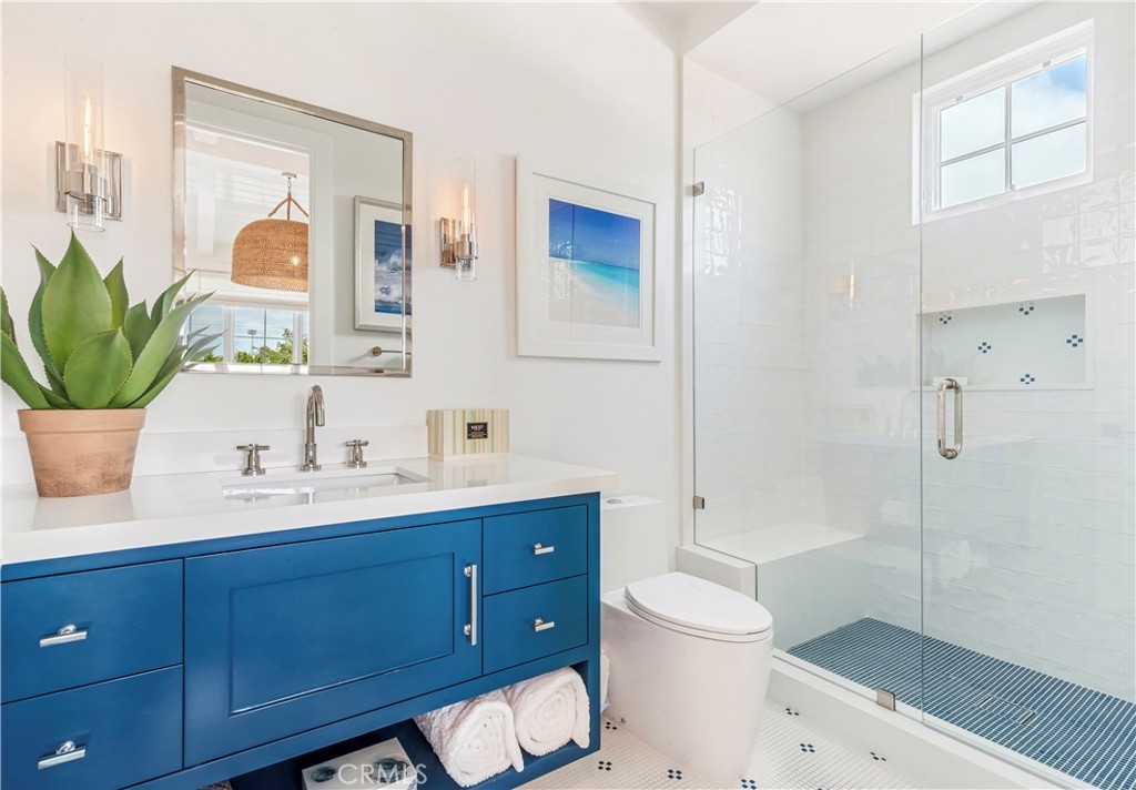 625 St James Road Newport Beach, CA 92663 - Photo 27 of 47 a bathroom with a toilet a sink a glass door a shower and a mirror