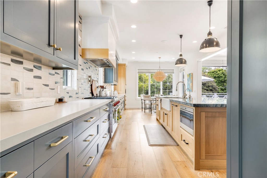625 St James Road Newport Beach, CA 92663 - Photo 7 of 47 a large kitchen with kitchen island a large window a sink and stainless steel appliances