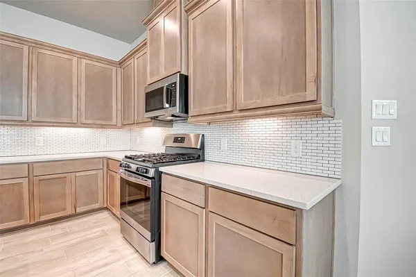 a kitchen with stainless steel appliances granite countertop white cabinets and a stove top oven
