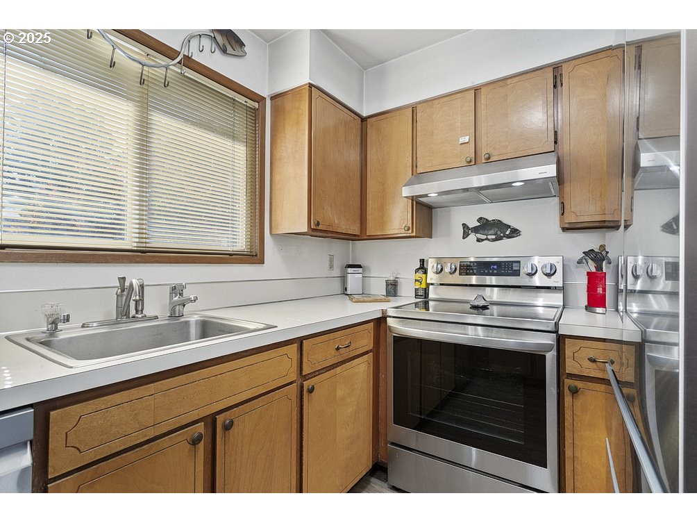 14850 Northeast Rose Parkway, Unit 67A Portland, OR 97230 - Photo 12 of 33 a kitchen with a sink stove and cabinets