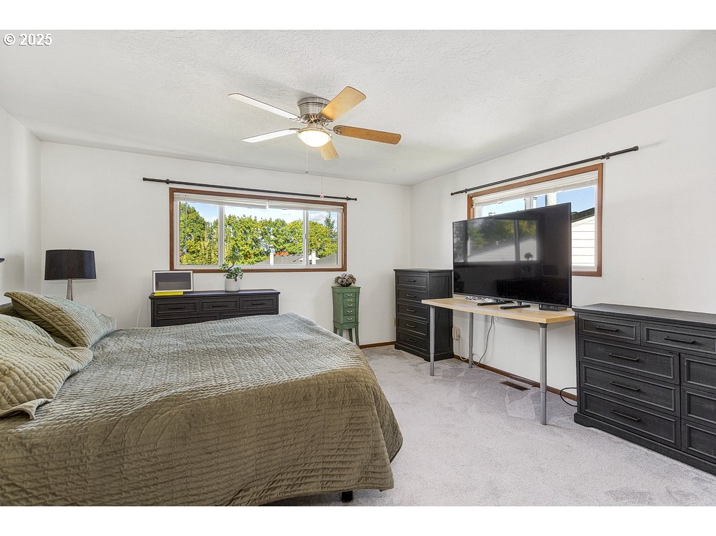 14850 Northeast Rose Parkway, Unit 67A Portland, OR 97230 - Photo 18 of 33 a bedroom with a bed and a flat screen tv