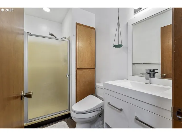 a bathroom with a sink a toilet a mirror and shower